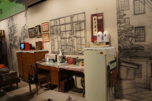 a room with a desk and a refrigerator