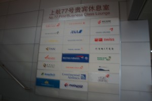 The image shows a signboard for the "No. 77 First/Business Class Lounge" at an airport. The signboard displays logos and names of various airlines that likely have access to this lounge. The airlines listed include:

1. Air China
2. ANA (All Nippon Airways)
3. Asiana Airlines
4. Austrian Airlines
5. Lufthansa
6. Swiss International Air Lines
7. Thai Airways
8. Singapore Airlines
9. United Airlines
10. Scandinavian Airlines (SAS)
11. Air Canada
12. Continental Airlines
13. Malaysia Airlines
14. Virgin Atlantic

The text on the signboard is written in both Chinese and English.