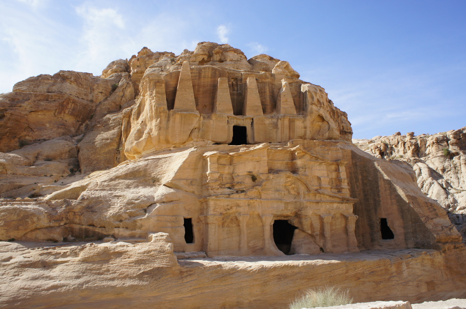 a rock structure with many windows with Petra in the background