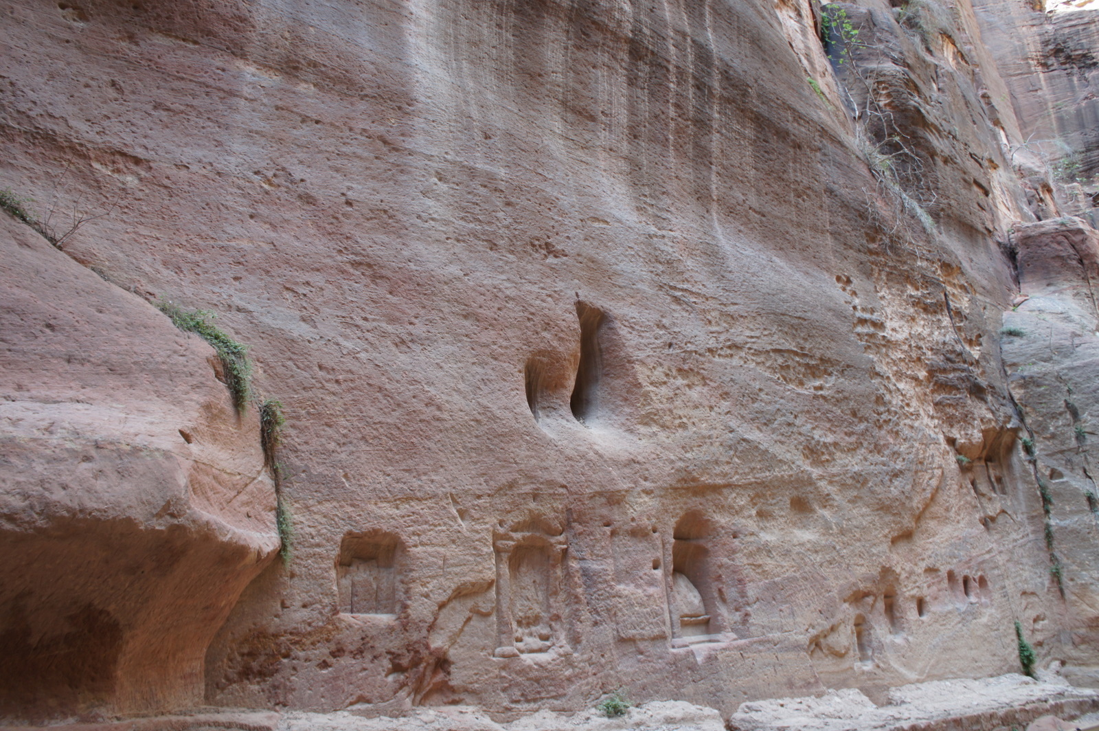 a rock wall with carved doorways