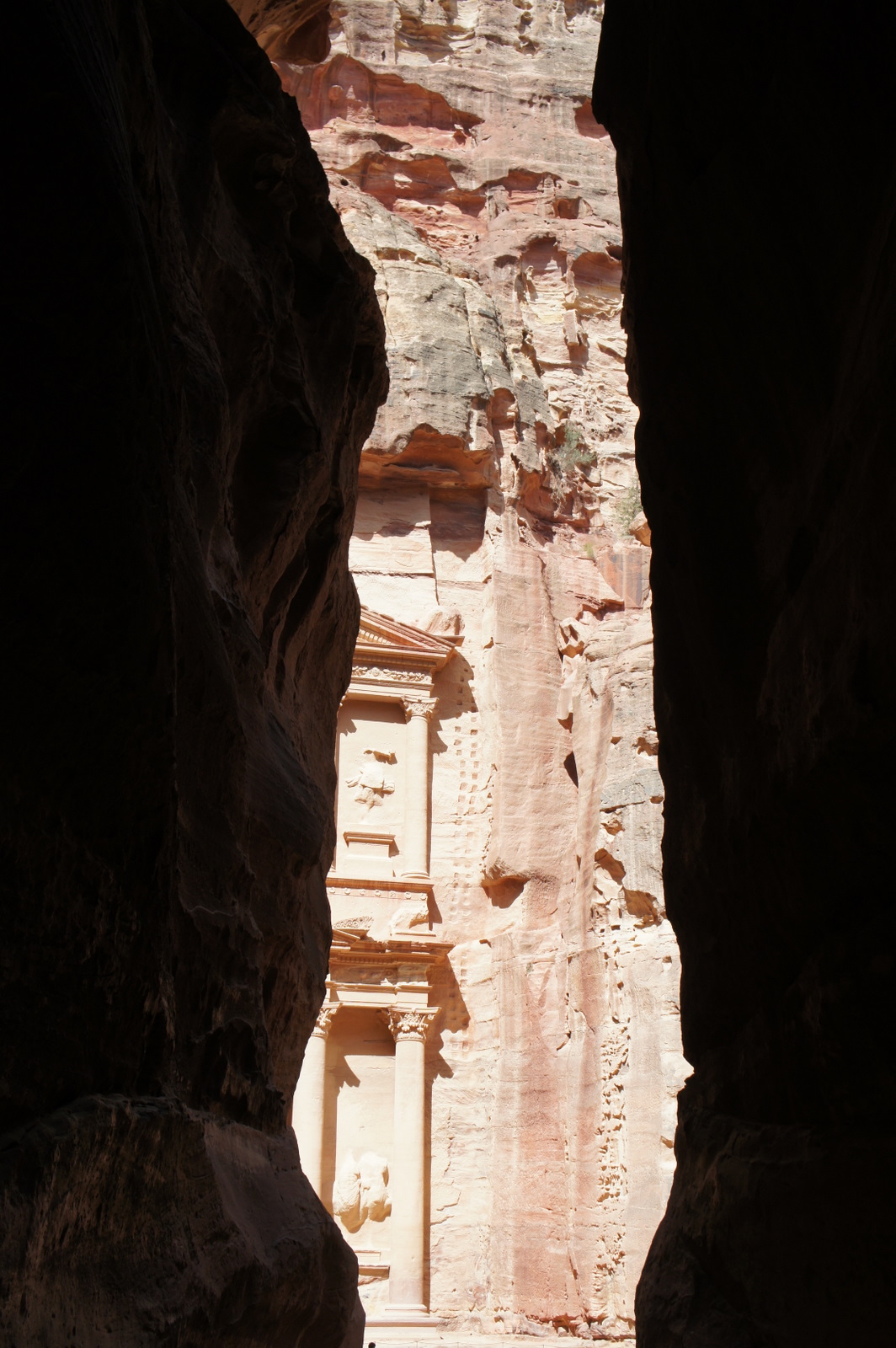 a rock cliff with a building in the background