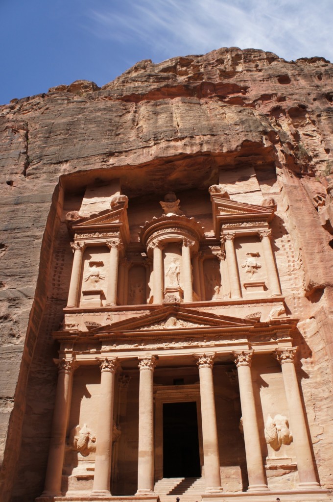 a stone building with columns and a doorway with Petra in the background