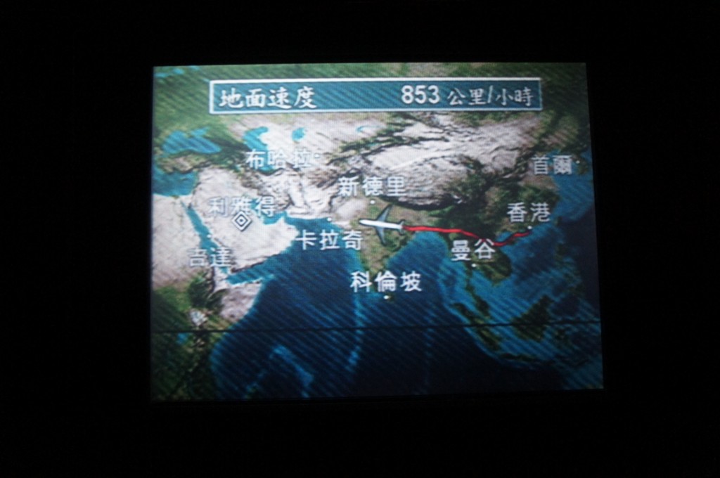 Alt text: A flight map display shows the route of an airplane traveling from Hong Kong to London. The map includes various cities labeled in Chinese characters, with a red line indicating the flight path. The current speed of the airplane is shown as 853 kilometers per hour.