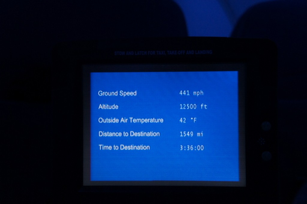 The image shows an in-flight information screen displaying the following details:

- Ground Speed: 441 mph
- Altitude: 12,500 ft
- Outside Air Temperature: 42&deg;F
- Distance to Destination: 1,549 mi
- Time to Destination: 3:36:00

The screen has a blue background with white text.
