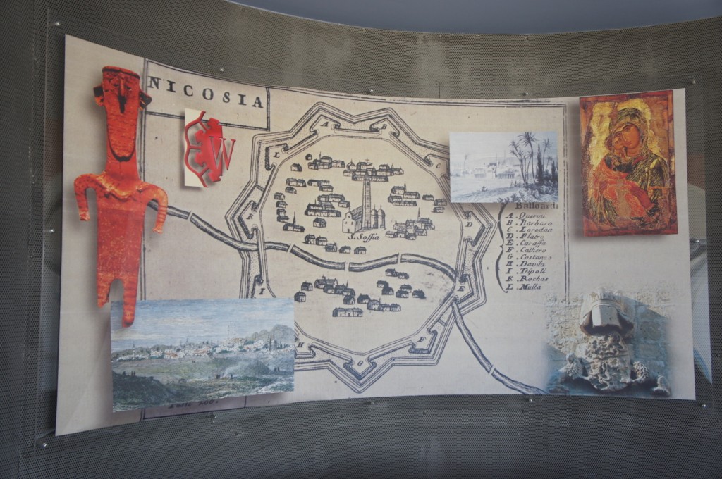 Alt text: A collage featuring a historical map of Nicosia in the center, surrounded by various images and artifacts. On the left, there is a red abstract sculpture and a small painting of a landscape. On the right, there is a black and white photograph of palm trees and a colorful religious icon depicting a saint. At the bottom right, there is a stone carving of a helmeted figure. The map includes labeled locations and a list of names.