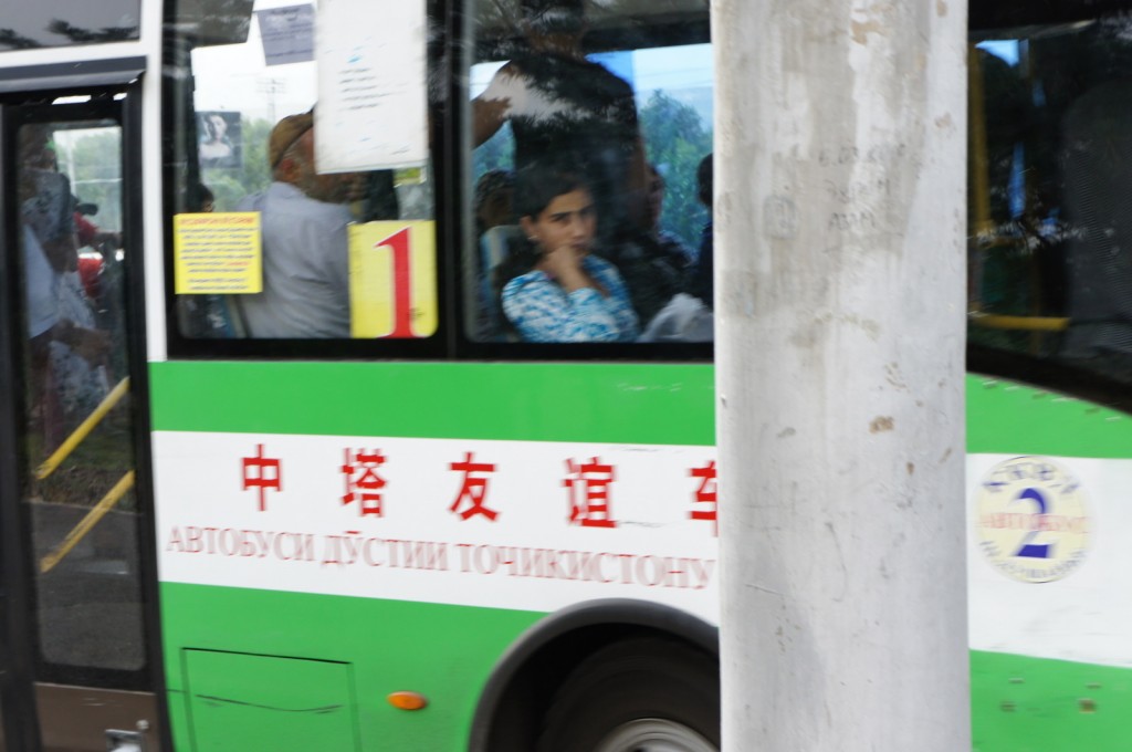 a green and white bus with people on the window