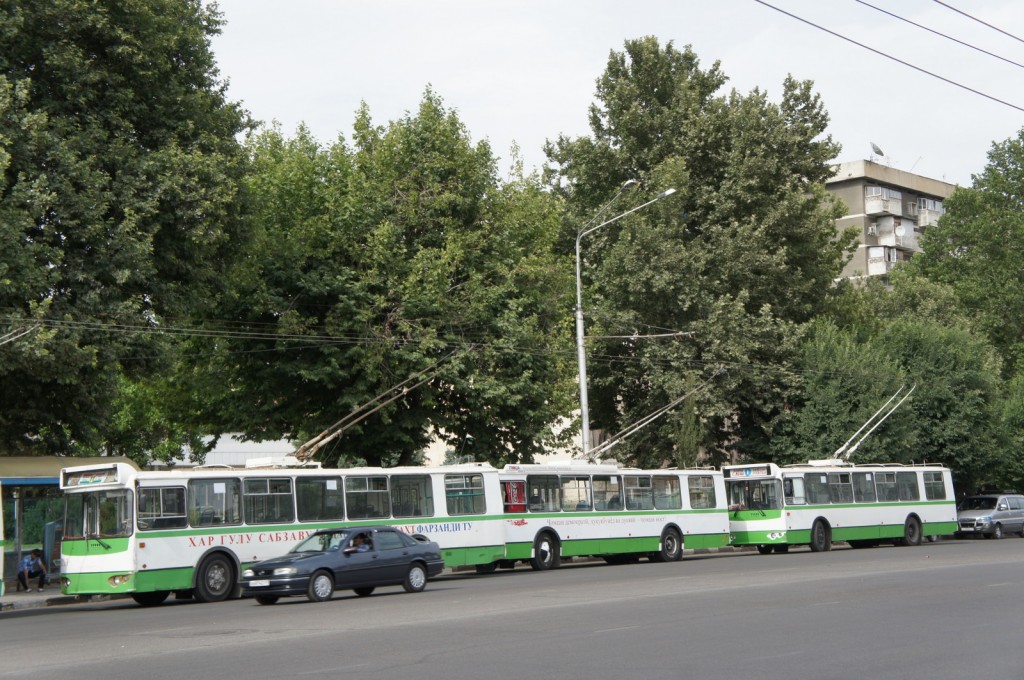 a group of buses and cars on a street