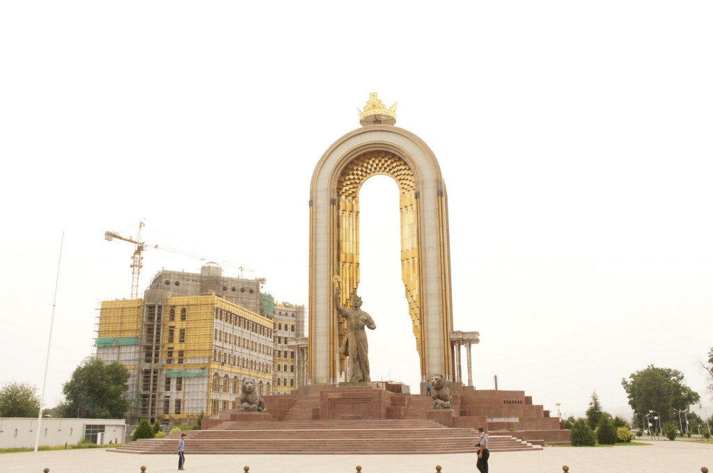 a large archway with a statue in the middle of a city