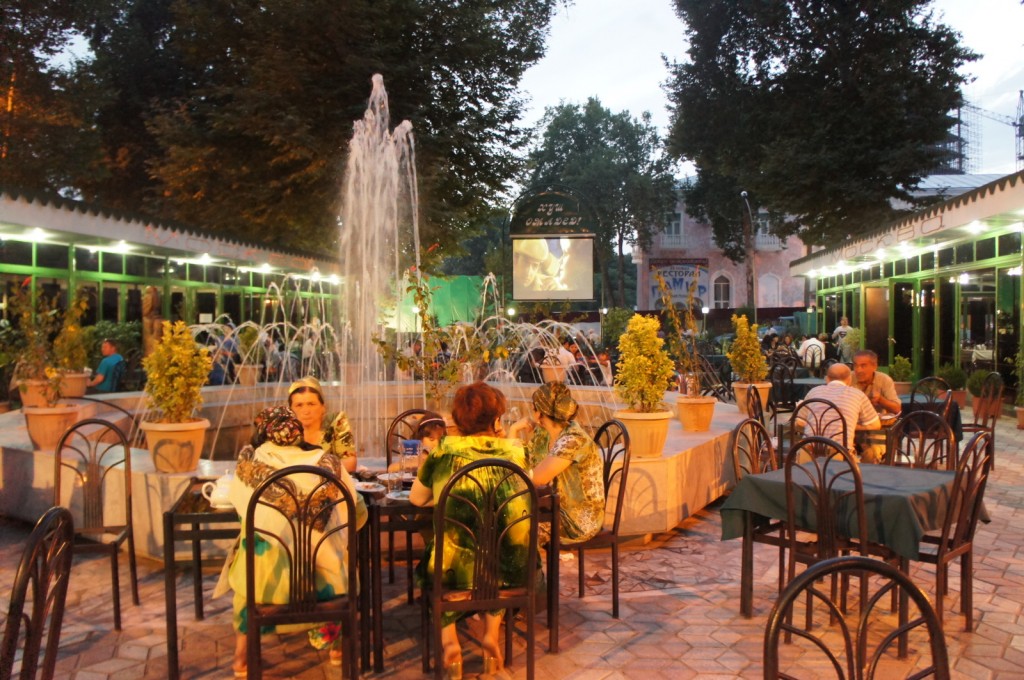 a group of people sitting at a table with a fountain
