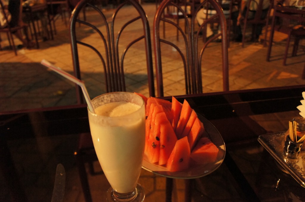a plate of fruit and a drink on a table