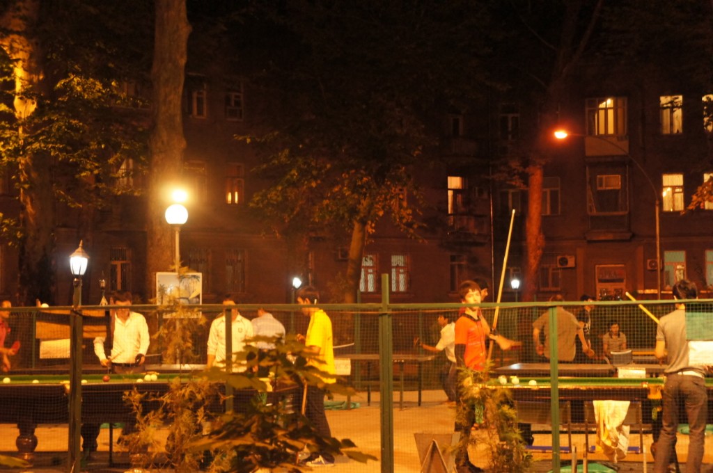 a group of people playing pool at night