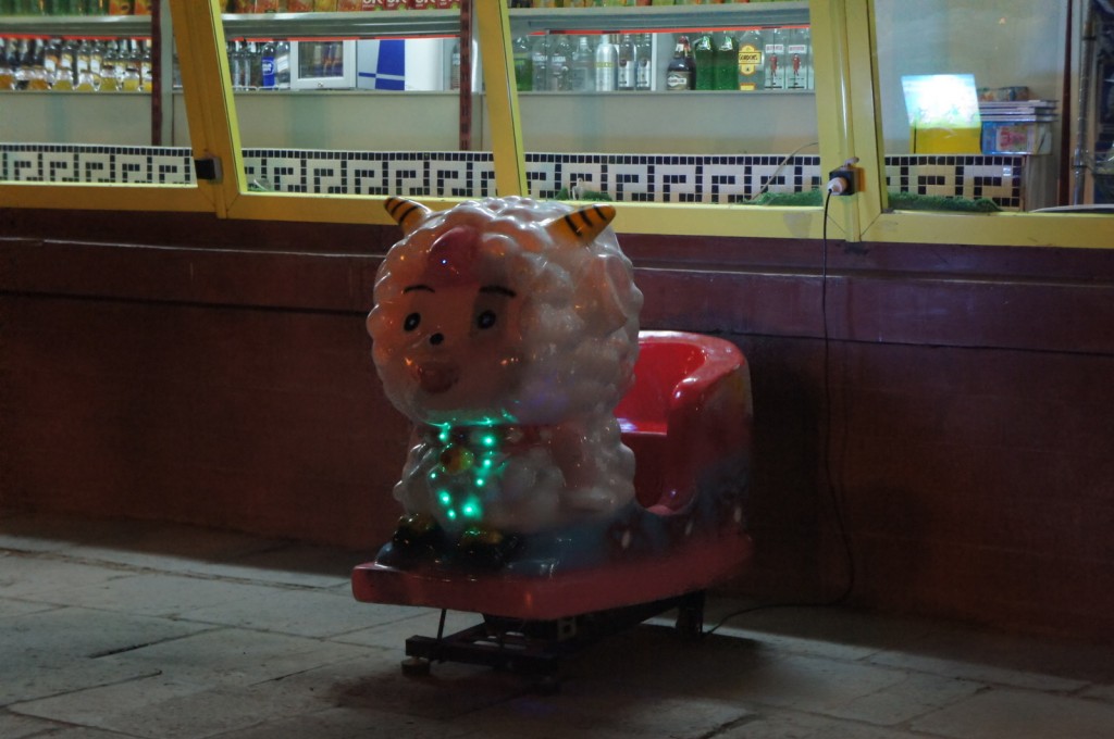 a toy sheep with lights on a carousel