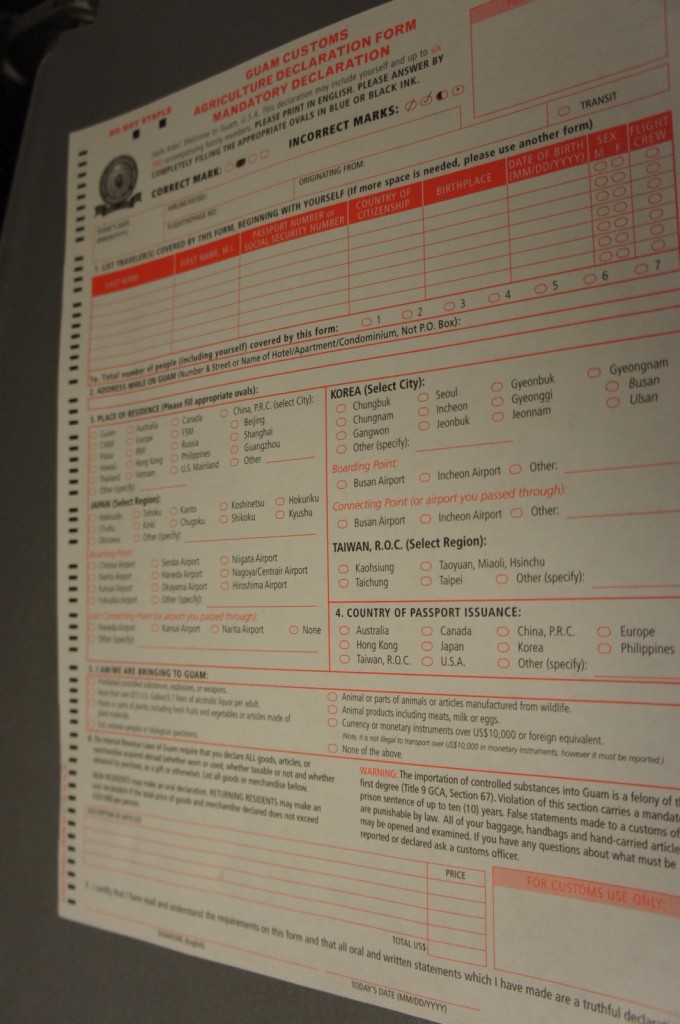 The image shows a "Guam Customs Agriculture Declaration Form." This mandatory declaration form is used for customs purposes when entering Guam. The form includes sections for personal information such as name, passport number, social security number, country of citizenship, and birthplace. It also has sections for listing the place of residence, country of passport issuance, and details about items being brought into Guam, including agricultural products and other goods. The form contains various checkboxes and fields to be filled out by the traveler, and it includes instructions and warnings about the importation of controlled substances and other regulations.