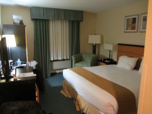 a hotel room with a bed and a chair