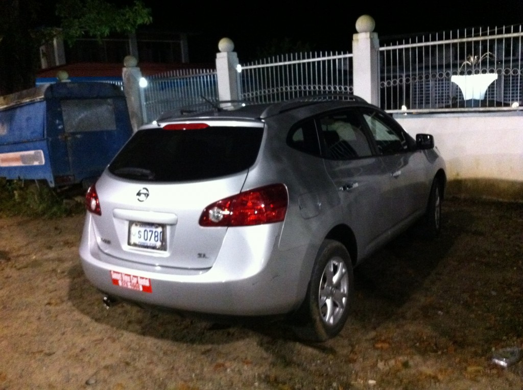 a car parked in front of a fence