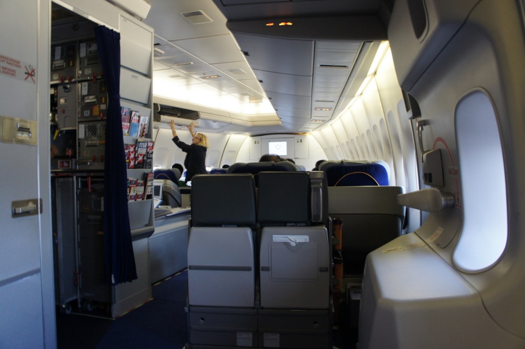 a woman standing in the middle of an airplane