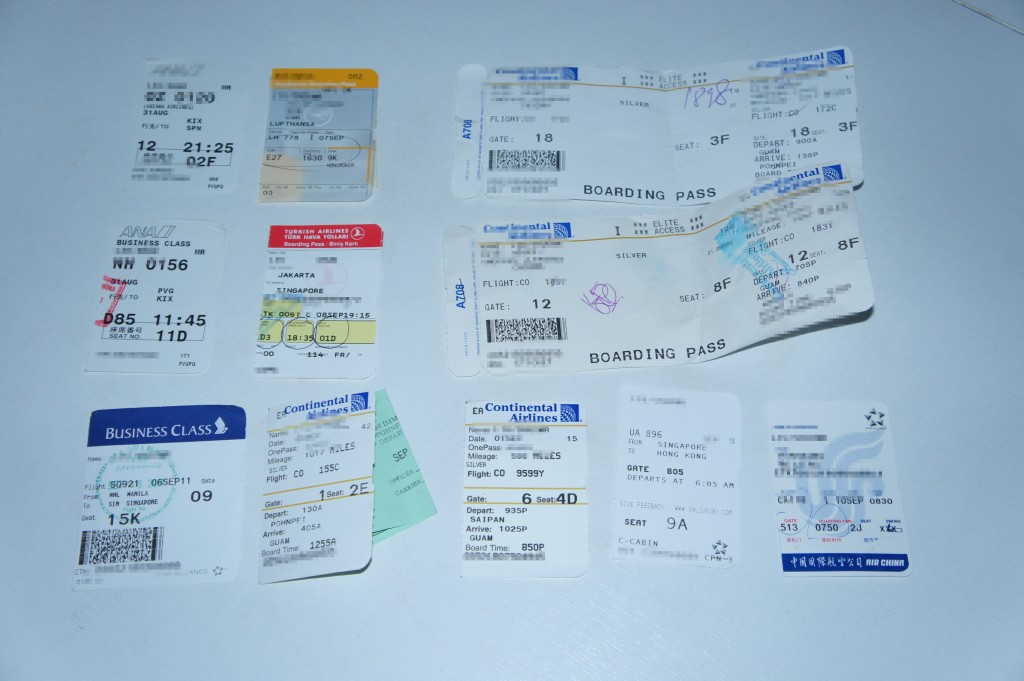 The image shows a collection of various airline boarding passes and tickets arranged on a flat surface. The boarding passes are from different airlines and display various flight details such as seat numbers, departure times, and destinations. Some of the boarding passes are labeled "Business Class" and "Silver Elite Access." The tickets are in different colors and formats, indicating they are from multiple airlines and flights.