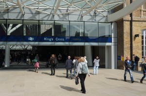 a group of people walking in front of a glass building