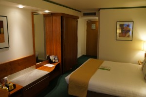 a hotel room with a bed and a mirror