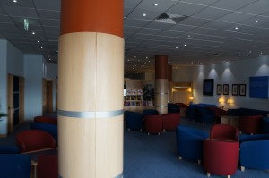 a room with a large column and chairs