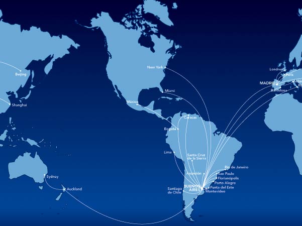 This image is a world map highlighting various flight routes originating from Buenos Aires, Argentina. The routes connect Buenos Aires to several cities across the globe, including New York, Miami, Mexico City, Lima, Bogota, Santa Cruz de la Sierra, Asuncion, Santiago de Chile, Rio de Janeiro, Sao Paulo, Florianopolis, Porto Alegre, Punta del Este, Montevideo, Madrid, London, Paris, Barcelona, Rome, Auckland, Sydney, Shanghai, and Beijing. The map has a dark blue background with the continents and flight paths marked in lighter shades.