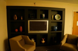 a room with a tv and shelves