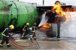 a group of firefighters spraying water on a large green machine