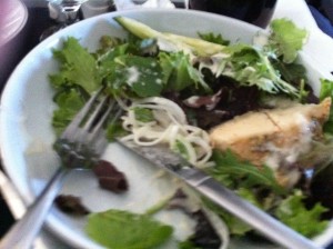 a plate of salad with a fork and knife