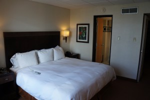 a bed with white sheets and a remote control