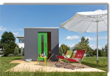 a small house with a green door and chairs