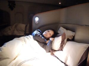 a woman lying in bed with a light on her head