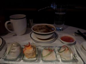 a bowl of soup and some food on a table