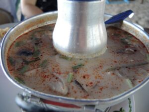 a bowl of soup with a metal tube