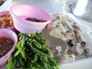 a plate of food with a bowl of sauce and greens