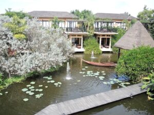 a pond with a fountain and a boat in it