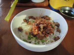 a bowl of noodles with meat and vegetables