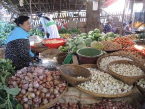 a woman selling vegetables at a market