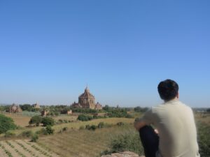 a man sitting on a rock looking at a building