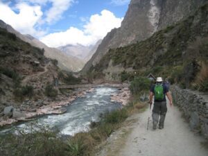 a man walking on a path with a river