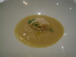 a bowl of soup with a small piece of food