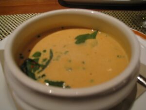 a bowl of soup with green leaves