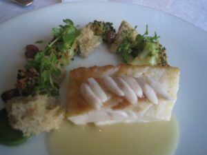 a plate of food with a piece of fish and broccoli