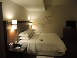 a bed with white sheets and pillows