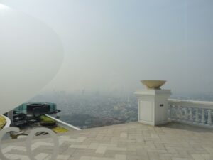 a white pillar on a brick surface with a city in the background