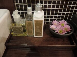 a group of bottles and a bowl of flowers