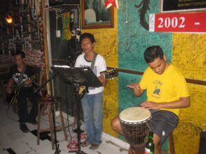 a man playing a guitar and a man playing a drum