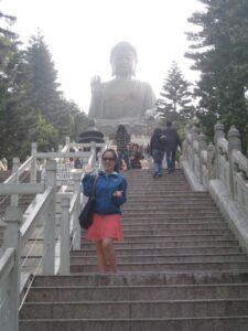 a woman standing on stairs with a statue in the background