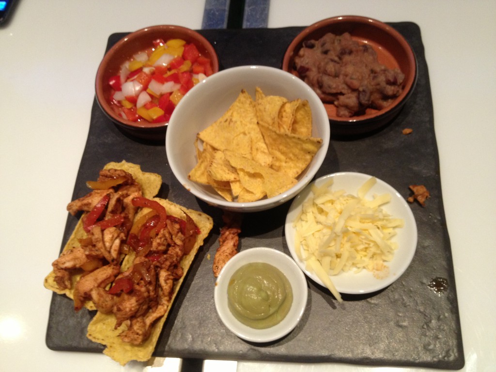 Mexican Platter (Chicken Fajita in a Taco Tray, Refried Beans, Peppers, Guacamole and Tortilla Chips.