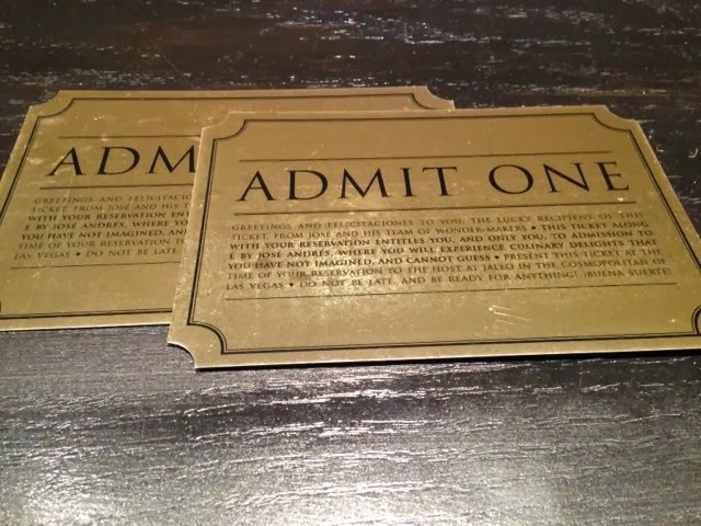 a pair of gold tickets on a wooden surface