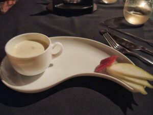 a cup of coffee and fruit on a plate
